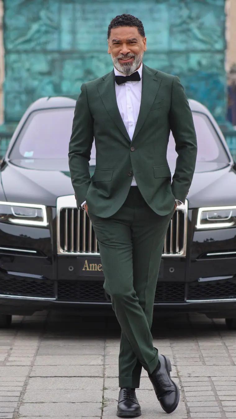 Man in green suit, white shirt and a black tie knot
