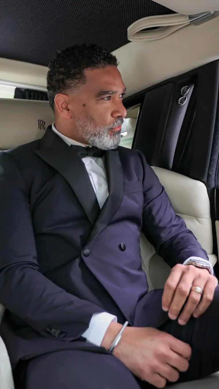 Man with dark blue suit in a luxury car