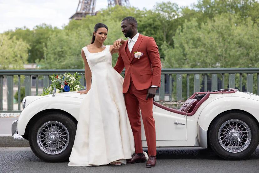 Couple in ceremony by a classy white car