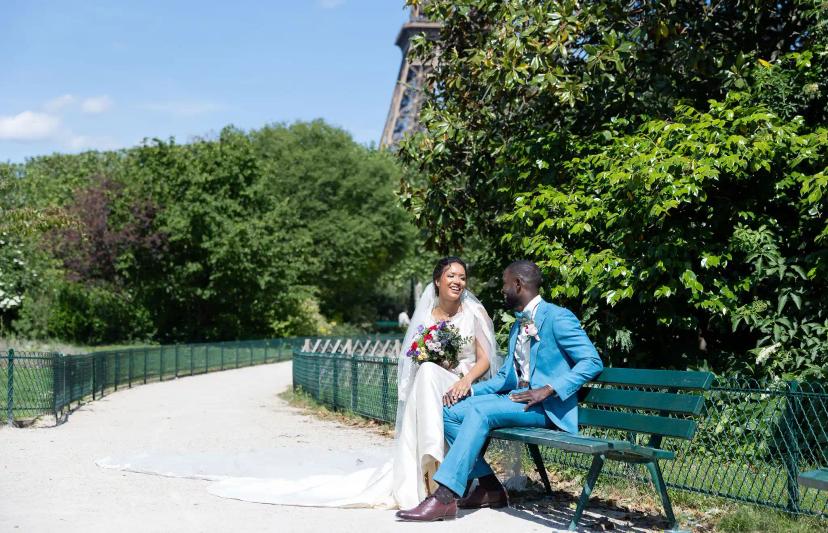 Couple in ceremony outfit sitting on a bench